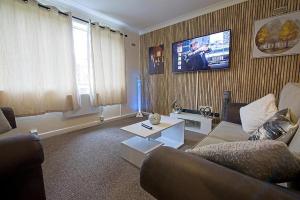 a living room with a couch and a tv at Sweet Dream Lodge in Manchester