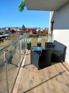 une terrasse avec deux chaises et une table sur une maison dans l'établissement Apartament Maria, à Sianożęty