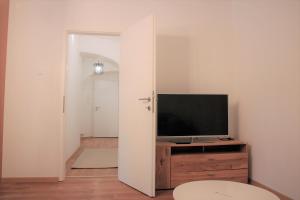 - un salon avec une télévision et une commode en bois dans l'établissement Aida, à Ljubljana