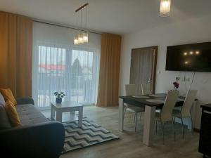 - un salon avec une table à manger et un canapé dans l'établissement Apartament Maria, à Sianożęty