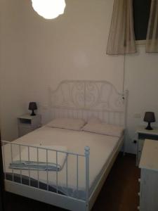 a bedroom with a white bed with a light above it at Casa acasaccio in Sciacca