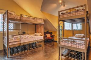 波德戈里察的住宿－Q PODGORICA Beds,Rooms and more，带椅子的客房内的两张双层床
