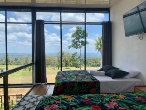 een slaapkamer met twee bedden en een groot raam bij Villa Aura in Fortuna