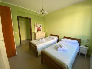 two beds in a room with green walls at VILLA DELLE POMELIE in Isola delle Femmine