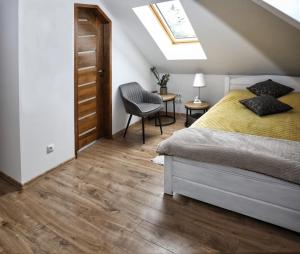 um quarto com uma cama, uma cadeira e uma clarabóia em Willa Vita - Apartment z kominkiem i dużym tarasem, Sauna, Jacuzzi, Altana z Grill, z możliwością wynajmu dotakowych pokoi - Schönes Appartement mit Kamin und großer Terrasse, Sauna, Jacuzzi, Pavilion mit Grill und der Option zusätzliche Zimmer zu mieten em Stegna