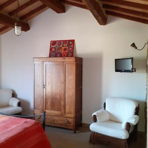 MonteneroにあるCastelvecchio B&Bのベッドルーム1室(ベッド1台、椅子2脚、テレビ付)