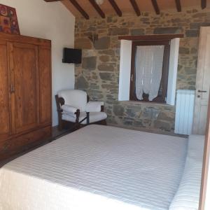 1 dormitorio con 1 cama y 1 silla en Castelvecchio B&B, en Montenero