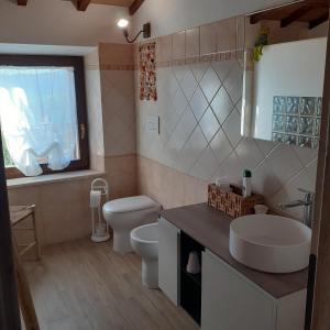 W łazience znajduje się umywalka, toaleta i lustro. w obiekcie Castelvecchio B&B w mieście Montenero