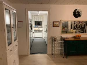 a kitchen with a hallway with a table and a refrigerator at OWN ROOM WITH BIG BED IN A BIG HOUSE! in Luleå