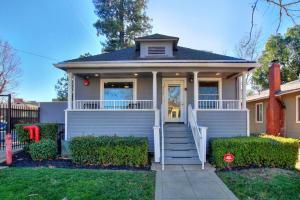 a white house with a porch and stairs at Extravagant Victorian Near UC Davis Medical Center in Sacramento