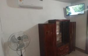 a fan next to a cabinet and a tv at El Remanso II in Durazno