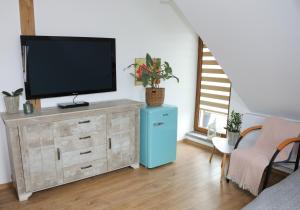 salon z telewizorem na drewnianej komodzie w obiekcie Willa Vita - Apartment z kominkiem i dużym tarasem, Sauna, Jacuzzi, Altana z Grill, z możliwością wynajmu dotakowych pokoi - Schönes Appartement mit Kamin und großer Terrasse, Sauna, Jacuzzi, Pavilion mit Grill und der Option zusätzliche Zimmer zu mieten w Stegnie
