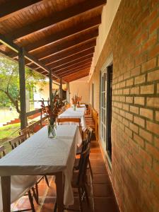 a row of tables on a patio with a brick wall at Casona Rural Km 1469 in Puerto Rico
