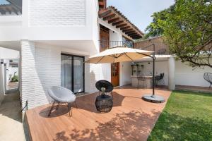 a patio with an umbrella and chairs and a table at Casa Naâmja in Tepoztlán