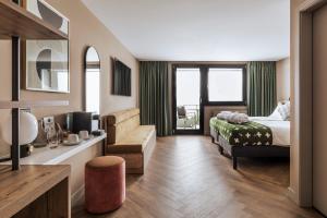 una camera d'albergo con un letto e un divano di Hotel Valaisia Crans Montana, a Faern Collection Resort a Crans-Montana