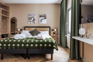 una camera da letto con un letto con una coperta verde di Hotel Valaisia Crans Montana, a Faern Collection Resort a Crans-Montana