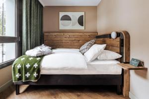 una camera con un grande letto con testiera in legno di Faern Crans-Montana Valaisia a Crans-Montana