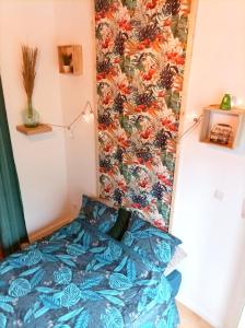 Le studio Naturel في هينان بومونت: غرفة نوم بسرير وجدار زهري