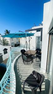 a patio with a table and chairs and an umbrella at 3 bedrooms appartement with sea view balcony and wifi at Trou aux Biches 1 km away from the slopes in Trou aux Biches
