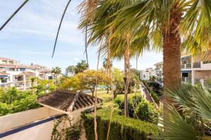 desde el balcón de un complejo con palmeras en Lorcrimar 3 Apto cerca de la playa con piscina, en Marbella