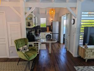 - un salon avec une table et une chaise verte dans l'établissement Villa Dali, Résidence Aquarelle, Sainte Rose, à Sainte-Rose