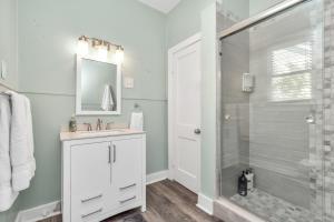 a bathroom with a shower and a sink and a mirror at 2 Kitchens,2 Living Rooms,4 Bedrooms-Close to all! in Galveston