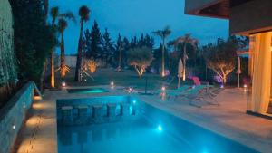 ein Pool im Hinterhof in der Nacht in der Unterkunft SOMPTUEUSE VILLA PISCINE chauffée et jacuzzi ARGAN GOLF- FIBRE OPTIQUE - NETFLIX - GOUVERANTE in Marrakesch