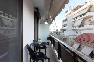 a balcony with two chairs and a table on a building at Chania City Luxury Dreams Apartment in the Heart of Chania in Chania