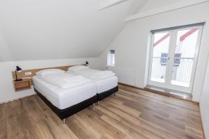 sypialnia z 2 łóżkami i dużym oknem w obiekcie Hrimland Guesthouse w Akureyri