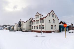 a snow covered street with houses and a stop sign at Hrimland Guesthouse in Akureyri