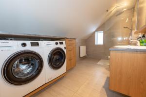 a laundry room with a washing machine and a sink at Hrimland Guesthouse in Akureyri