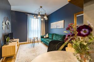salon z niebieskimi ścianami i zieloną kanapą w obiekcie Villa Garden Jagiellończyka w Olsztynie