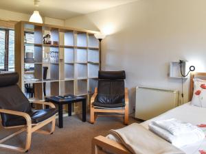 a bedroom with two chairs and a bed and a desk at Jims Place - Uk42085 in Sedbergh