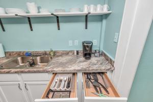 a kitchen with a sink and a counter with utensils at Sleeps 19! 3 Kitchens, LR's, 4 BR 4.5 BTH - Beauty in Galveston