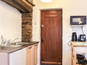 a kitchen with a sink and a wooden door at Jims Place - Uk42085 in Sedbergh