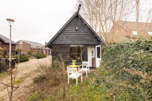 uma pequena casa preta com uma mesa e duas cadeiras em The Stables em Kampen