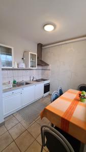una cucina con tavolo, lavandino e bancone di Gabi Apartman a Hajdúszoboszló
