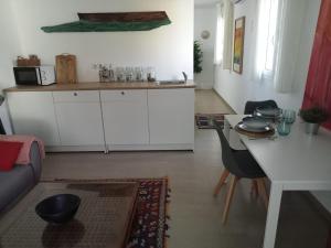 a kitchen with white cabinets and a table and chairs at Dormir entre limones, Casa de invitados en vivienda familiar in Dos Hermanas