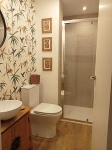 a bathroom with a toilet and a sink and a shower at Dormir entre limones, Casa de invitados en vivienda familiar in Dos Hermanas