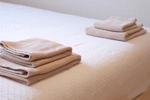 uma pilha de toalhas sentadas em cima de uma cama em Bivalvia Apartments em Koper