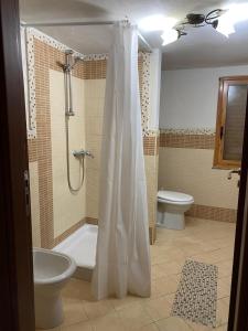 een badkamer met een douche, een bad en een toilet bij Villa Sophie in SantʼAgata di Militello