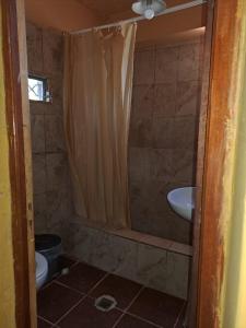 a bathroom with a shower and a toilet and a sink at Carnavalito Hostel Tilcara in Tilcara