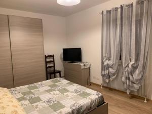 - une chambre avec un lit et une télévision dans l'établissement Casa Vacanza da Violetta, à Faedis