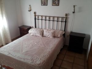 a bedroom with a large white bed with pillows at Casa Rural La Rosa de los Vientos in Fuente de Piedra