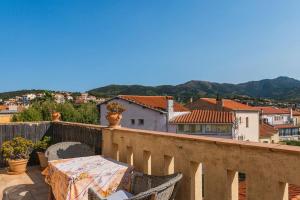 a table on a balcony with a view of a city at Regina's Banyuls - Mountain view in Banyuls-sur-Mer