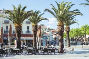 a group of palm trees with tables and chairs at Regina's Banyuls - Mountain view in Banyuls-sur-Mer