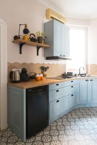 een keuken met blauwe kasten en een zwarte vaatwasser bij Dragonfly Residence in Belgrado