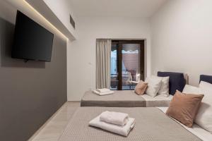 a room with two beds and a flat screen tv at Chania City Luxury Dreams Apartment in the Heart of Chania in Chania