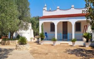 a white house with plants in front of it at Villa Trullo Septis in Ostuni