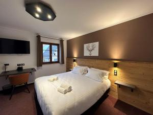 - une chambre avec un grand lit et 2 serviettes dans l'établissement Hôtel au Heimbach, à Lembach
